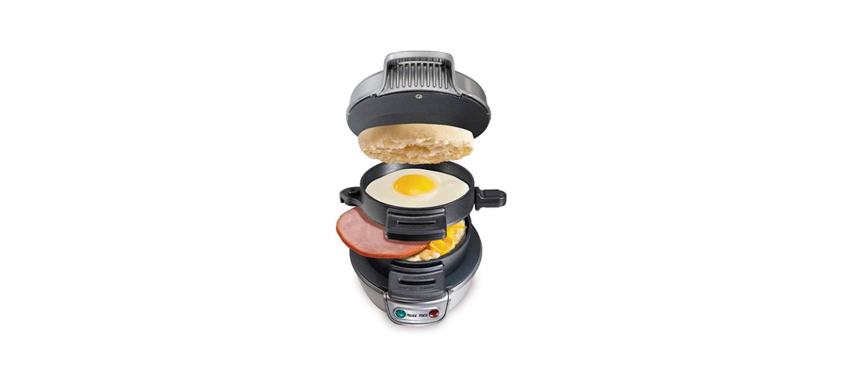 A breakfast sandwich maker shown with an English muffin, ham and a fried egg on its varying parts