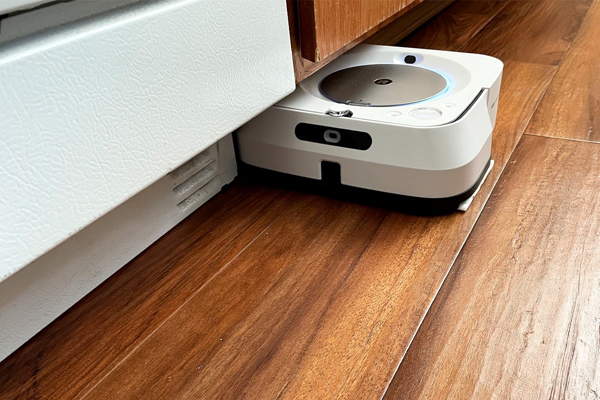 Braava Jet M6 navigating on hardwood flooring in kitchen next to stove