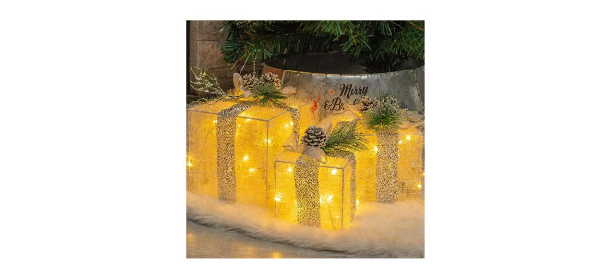3 illuminated Christmas gift-shaped decorations under a Christmas tree 3 illuminated Christmas gift-shaped decorations under a Christmas tree