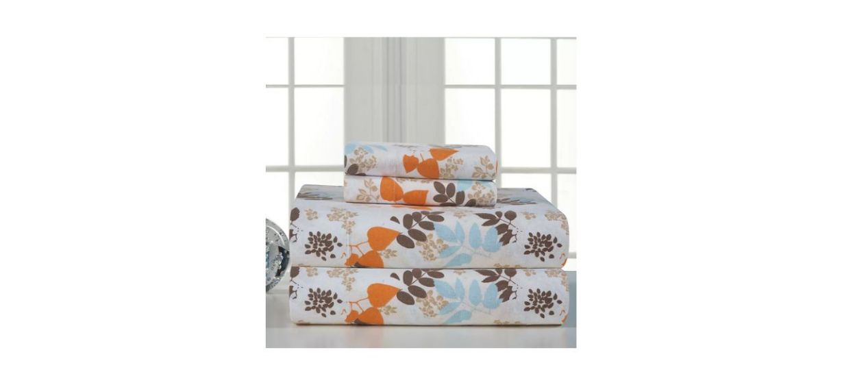 A set of white sheets with orange, brown and light blue leaf patterns on it