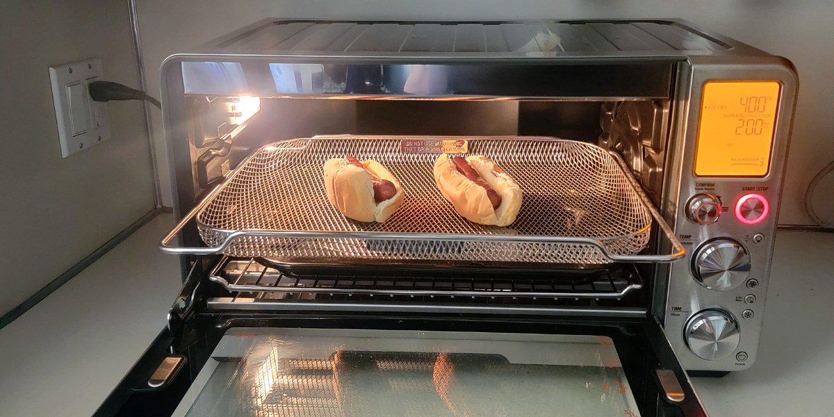 Breville Joule Oven Air Fryer Pro with open door and hot dogs inside Breville Joule Oven Air Fryer Pro with open door and hot dogs inside