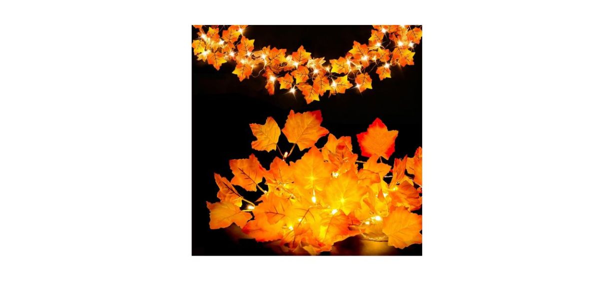 A lighted garland of fake orange maple leaves on a black background A lighted garland of fake orange maple leaves on a black background