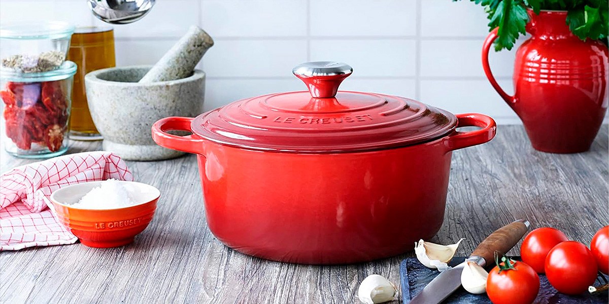Le Creuset Round Dutch Oven on countertop with knife and vegetables Le Creuset Round Dutch Oven on countertop with knife and vegetables