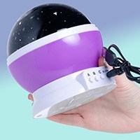 a hand holding a galaxy projector