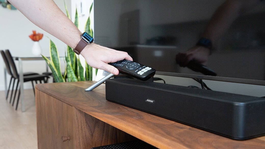 Person touching a soundbar on console table