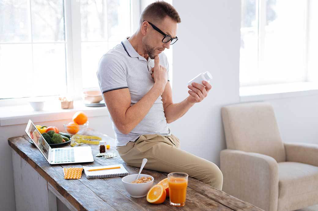 man holding bottle on table