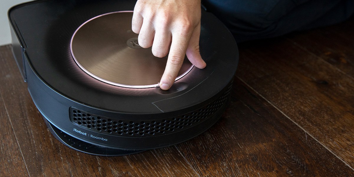 Finger touching &quot;Clen&quot; button on robotic vacuum