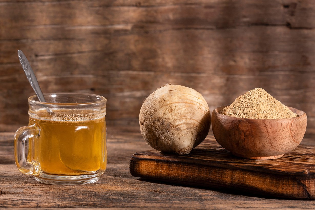 a glass of maca drink and a bowl of maca powder