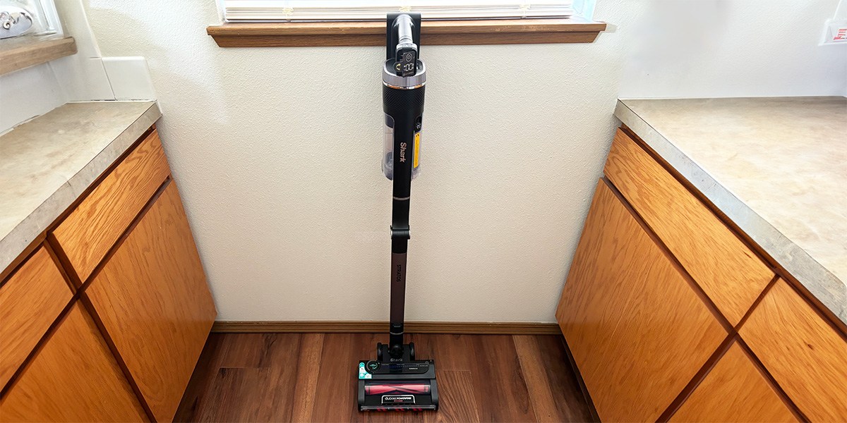 Shark Vertex Cordless Ultralight Stick Vacuum leaning against wall in kitchen